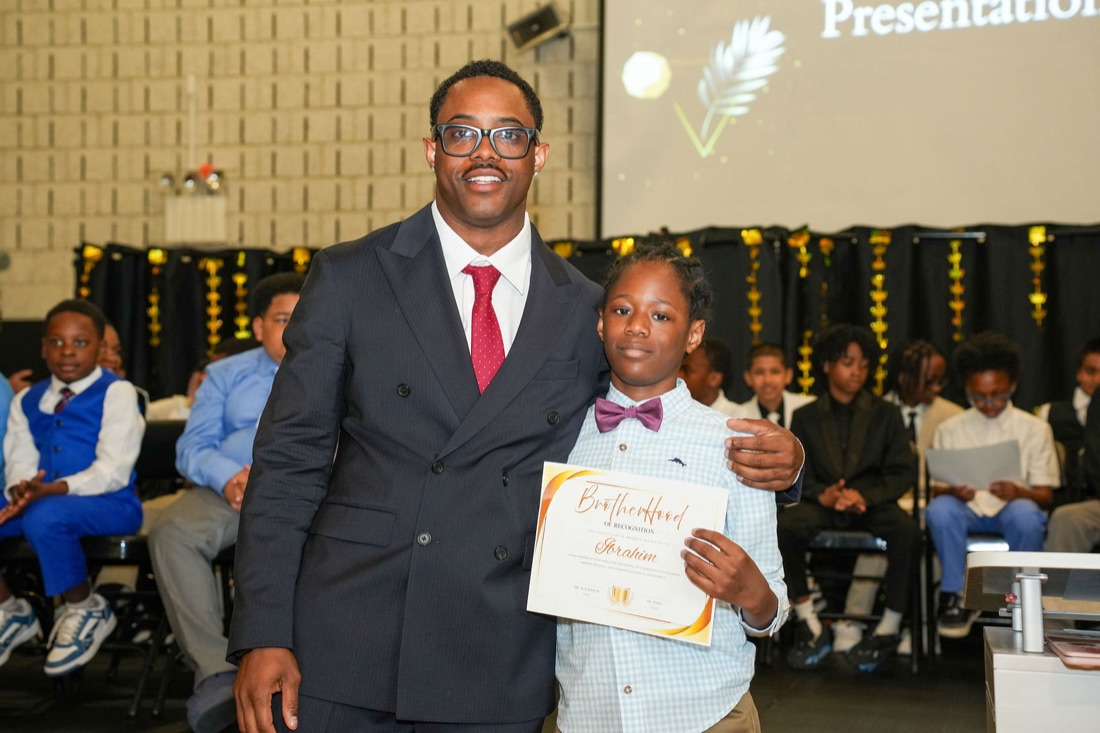 A young man and a mentor with his induction certificate.