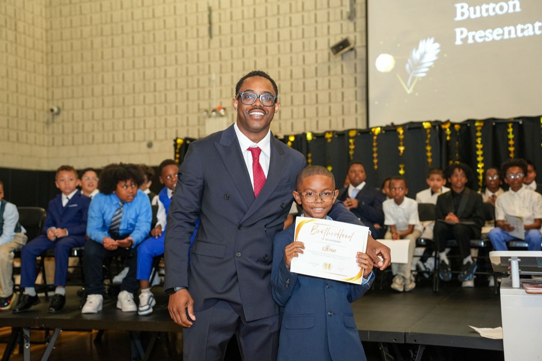 An inductee and a mentor on stage.