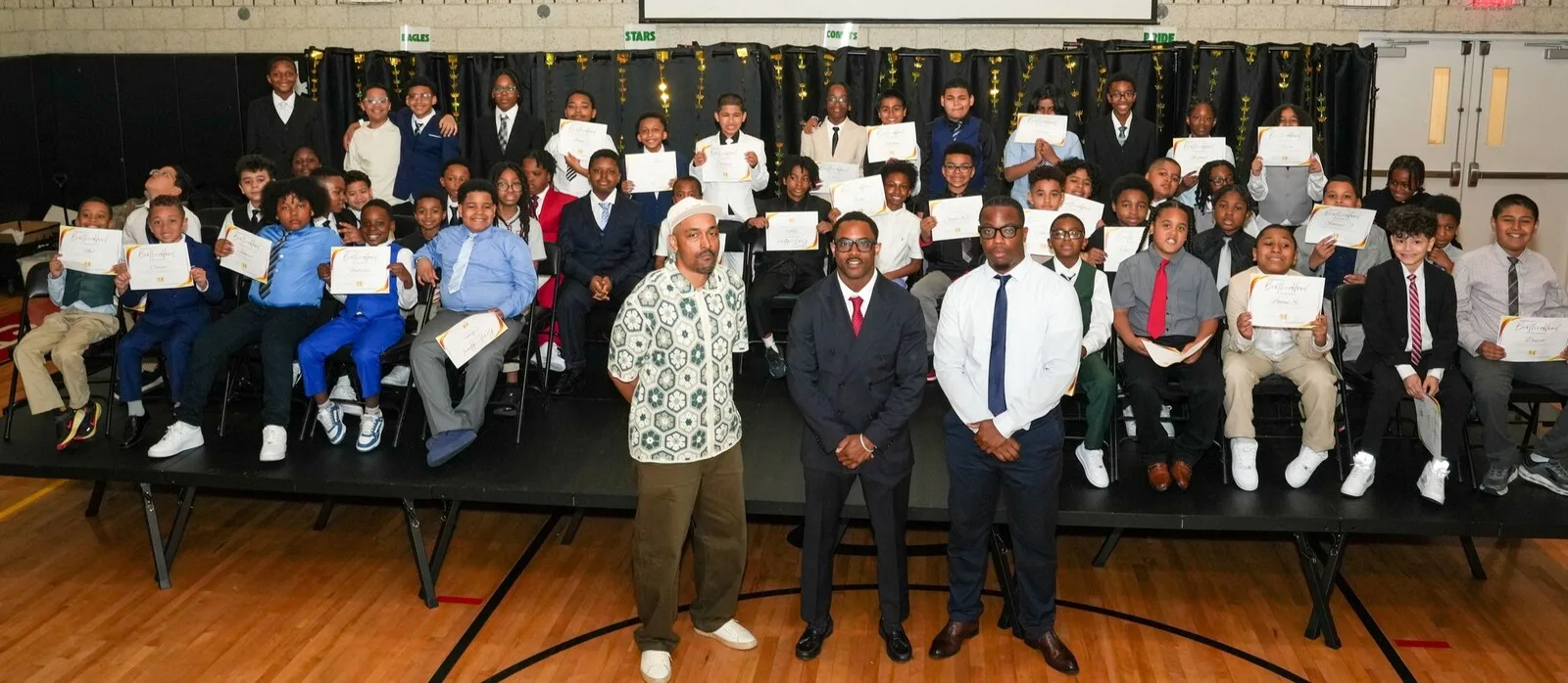 The inaugural Brotherhood class together on stage at the induction ceremony, certificates in hand.