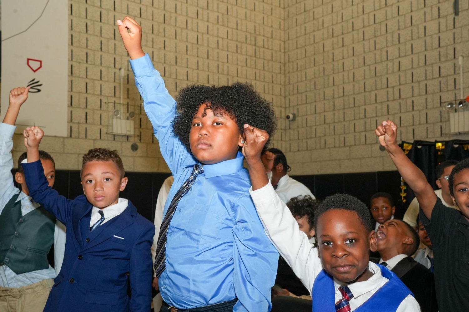 Young men cheering with raised fists at the induction ceremony.