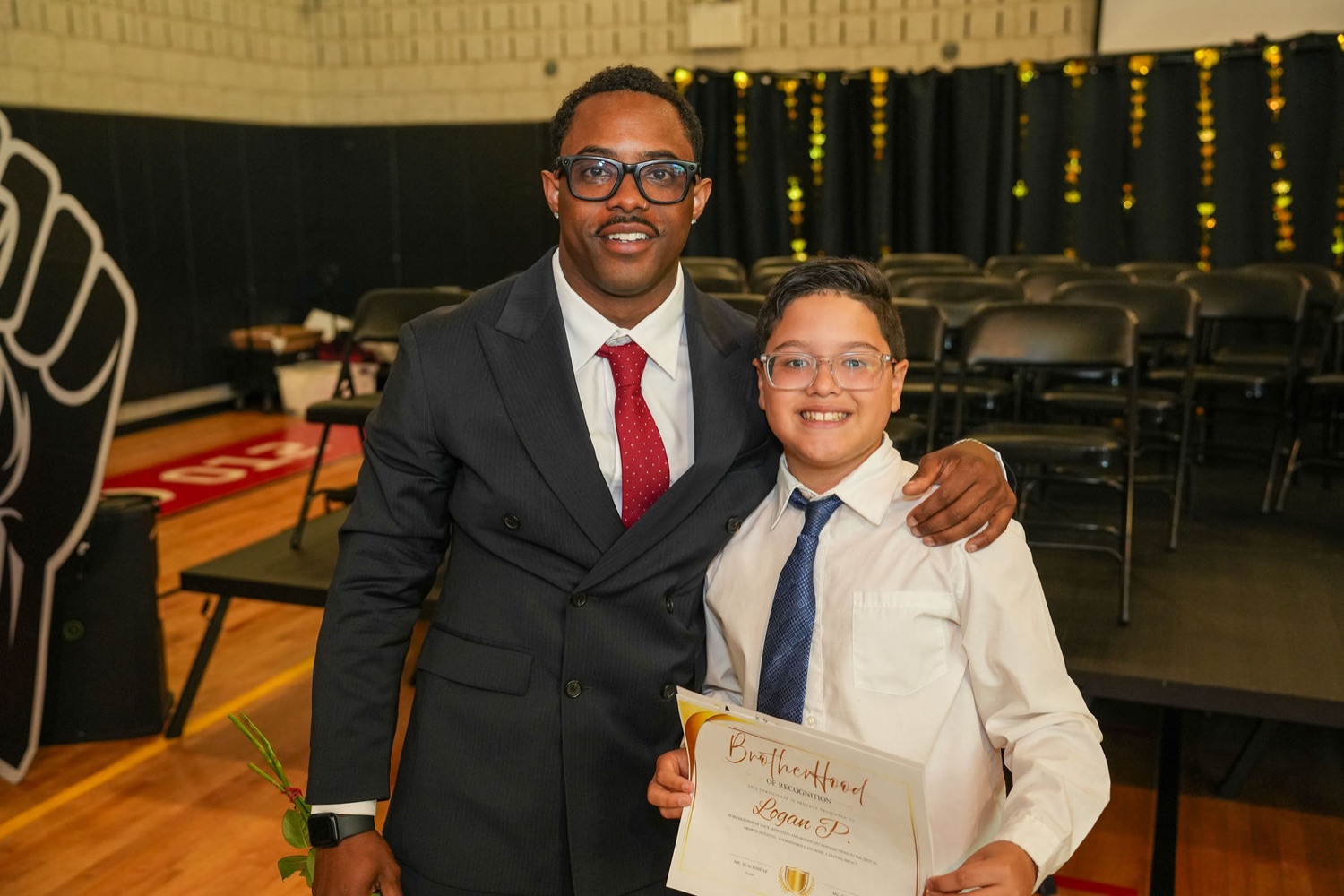 A young man with his Brotherhood certificate beside founder Kale Blackshear.